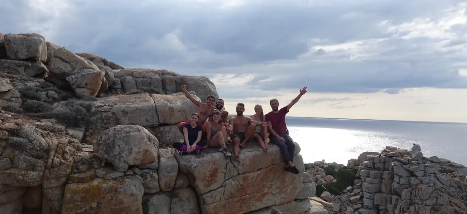 Un gruppo di arrampicatori esulta su una scogliera sul mare