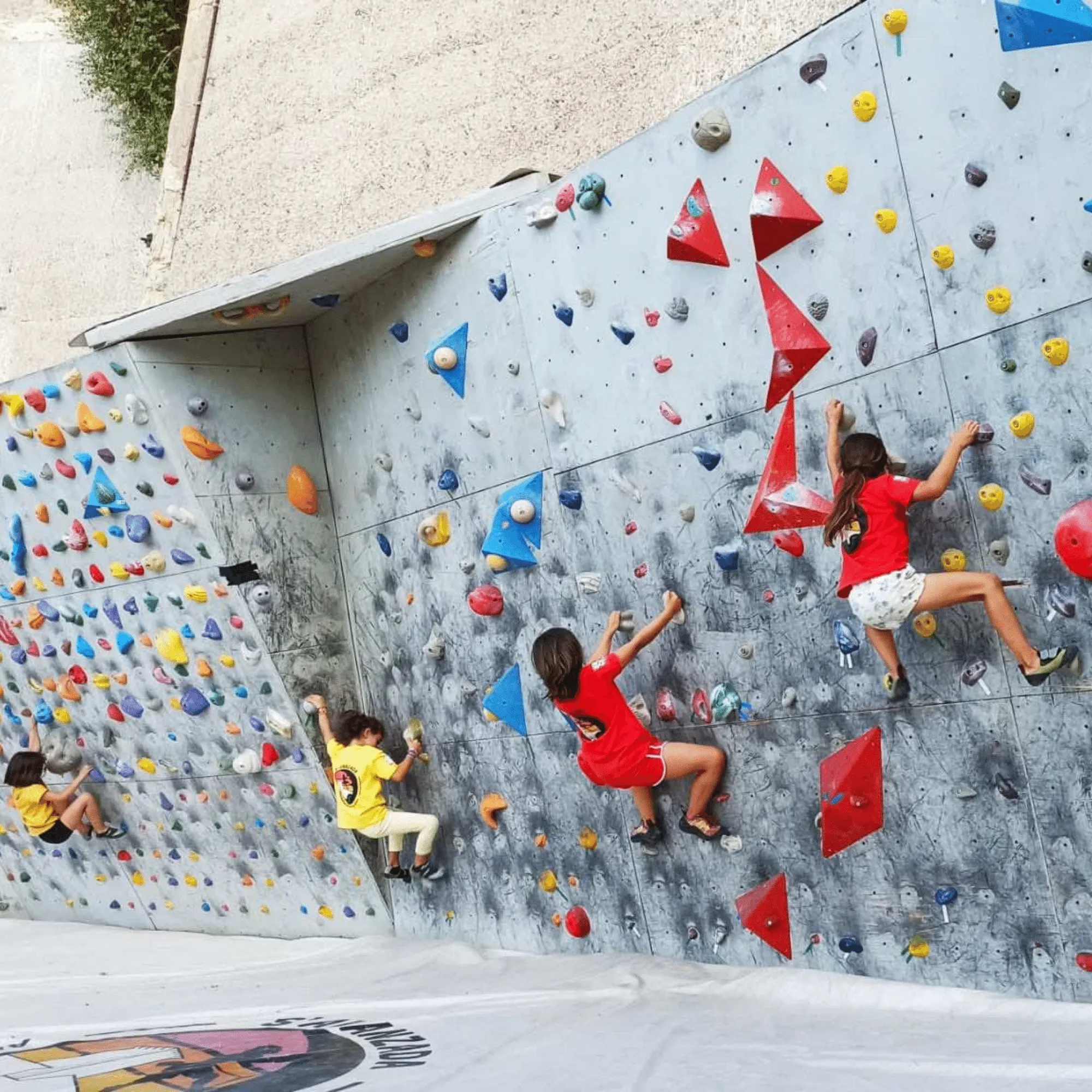 Una classe di bambini arrampica sull’area boulder
